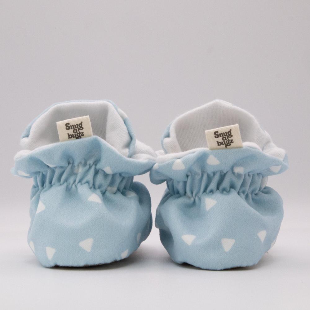 baby booties that stay on featuring white triangles on a baby blue background print, with non-slip soles and adjustable snap closure. Made from organic cotton.
