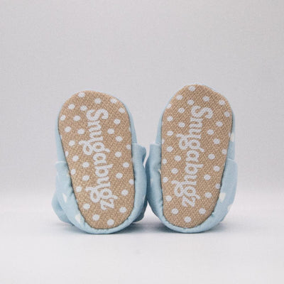baby booties that don't fall off featuring white triangles on a baby blue background print, with non-slip soft soles. barefoot baby shoes. Made from organic cotton.