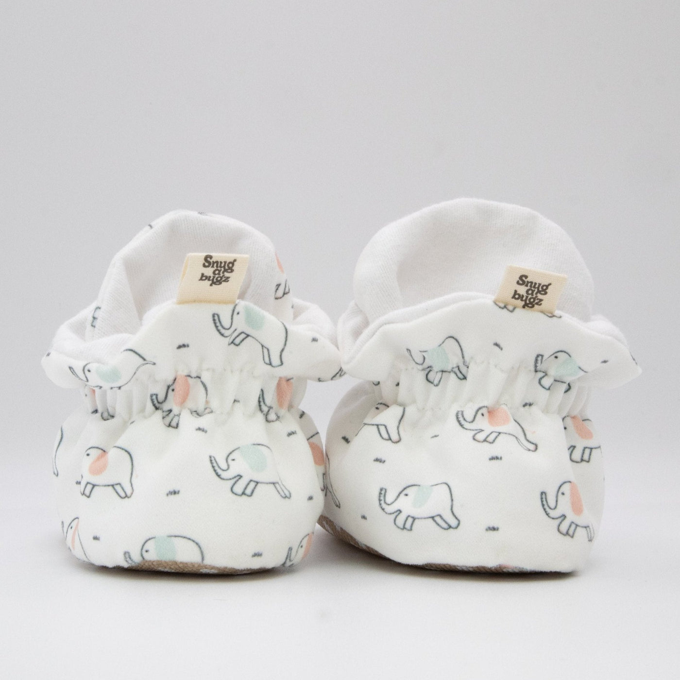 Gender Neutral white baby booties that stay on for infants made with soft organic cotton, sustainable, with flexible non-slip soles. Barefoot soft sole baby shoes. in gift box for baby shower gift or new baby gift idea. Cute Elephant Print