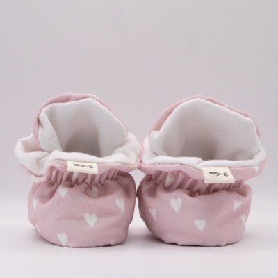 Snugabugz pink baby girl booties that stay on for infants made with soft organic cotton, sustainable, with flexible non-slip soles. Barefoot soft sole baby shoes in gift box for baby shower gift or new baby girl gift idea.